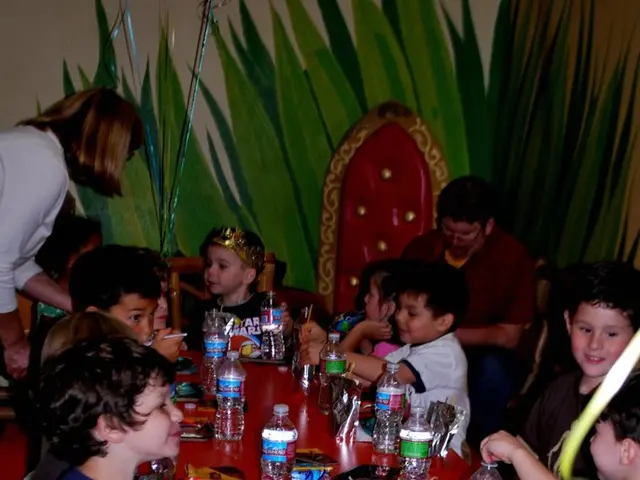 Some children gathered at a table having snacks at a birthday party.