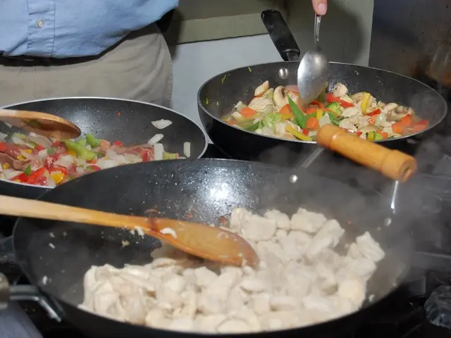 In this image we can some food items in the pans, which are on the stove, we can see spoons, one...