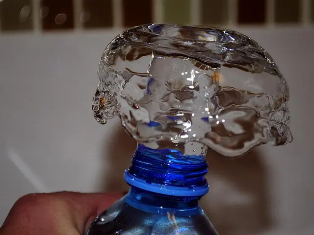 A human is pressing this water bottle and water is coming out.