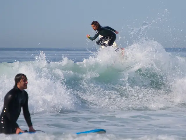 There are two members in this picture. One is surfing on the ocean tides, on the surfing board. In...